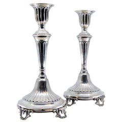 Silver candlesticks w/ fluting resting on circular bases w/ four cut-out feet