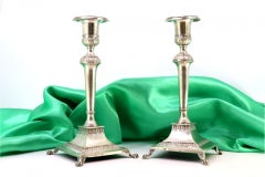 Candelieri in argento con rilievi e posti su basi quadrate con quattro piedi a forma di artiglio