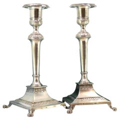 Silver candlesticks w/ reliefs
placed on square bases w/ four claw-shaped feet