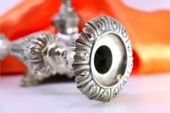 Candelieri d'argento con steli a rilievo d'acanto su basi quadrate cave