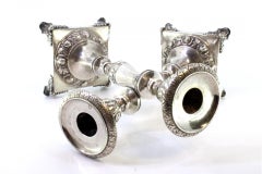 Silver candlesticks with embossed florals on square bases with four raised feet