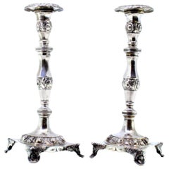Silver candlesticks with embossed florals on square bases with four raised feet