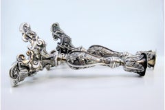Silver candlesticks with embossed flowers and acanthus leaves on three feet