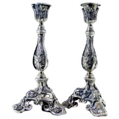 Silver candlesticks with embossed flowers and acanthus leaves on three feet