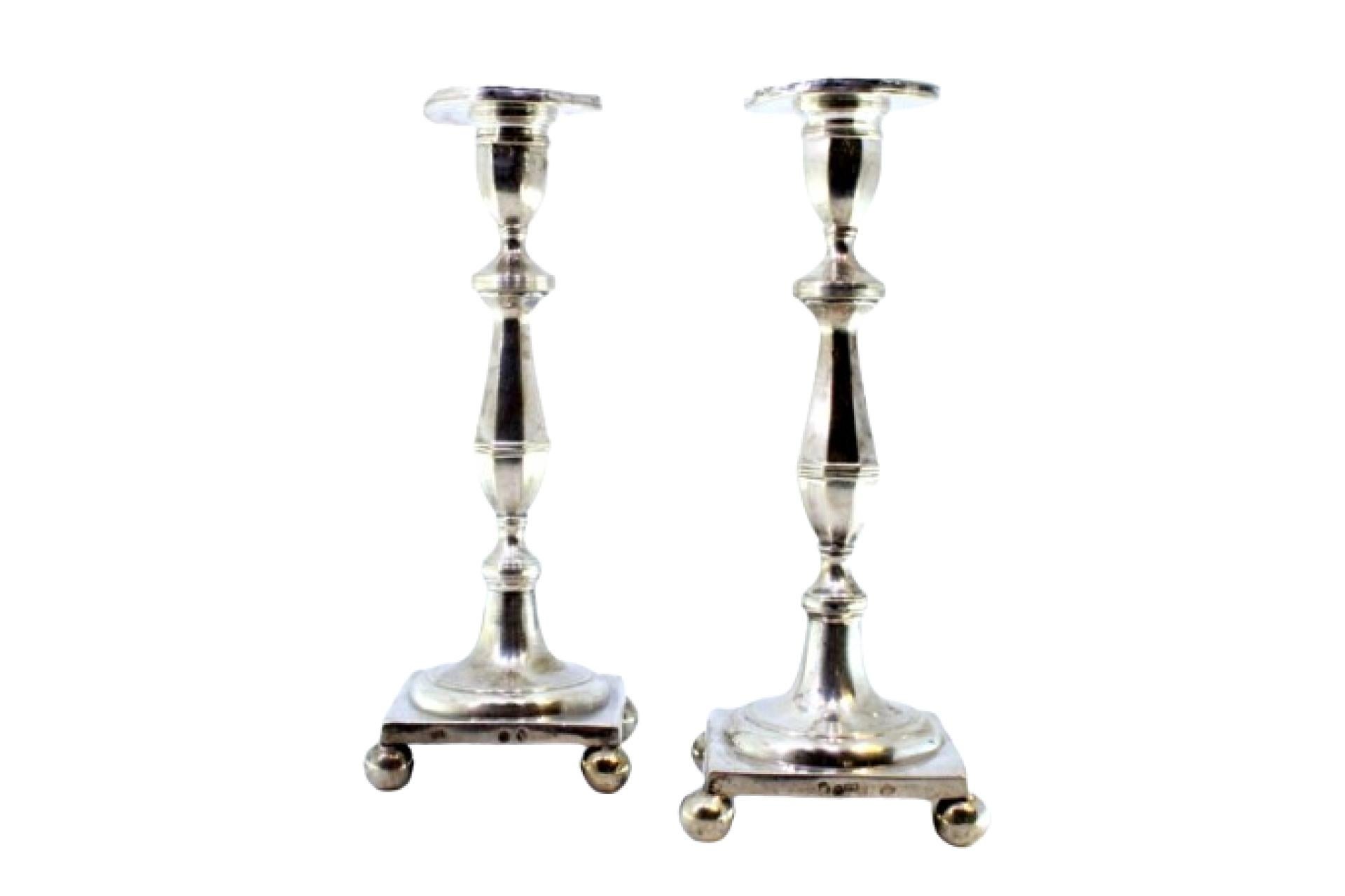 Silver candlesticks with embossed stems on square bases with four spheres