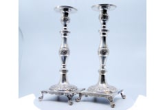 Silver candlesticks with engraved floral stems on four-footed square bases