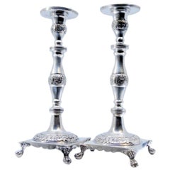 Silver candlesticks with engraved floral stems on four-footed square bases