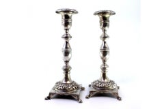 Silver candlesticks with engraved shafts on floral bases with claw feet