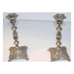 Silver candlesticks with floral embossing, square bases & claw feet