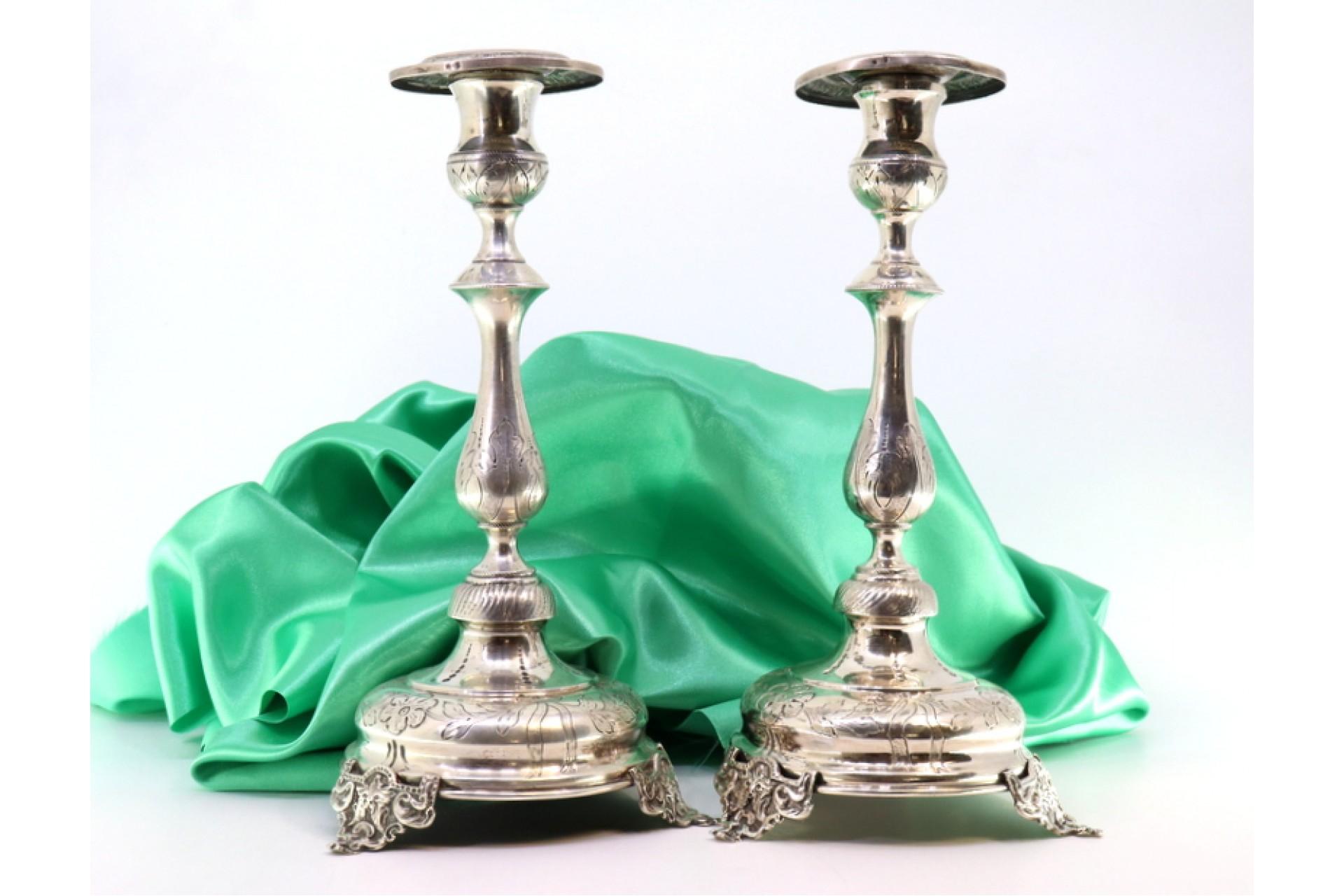 European Silver candlesticks with floral engravings on circular bases with three feet For Sale