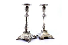 Candelieri in argento con incisioni floreali su basi quadrate rialzate con quattro piedini