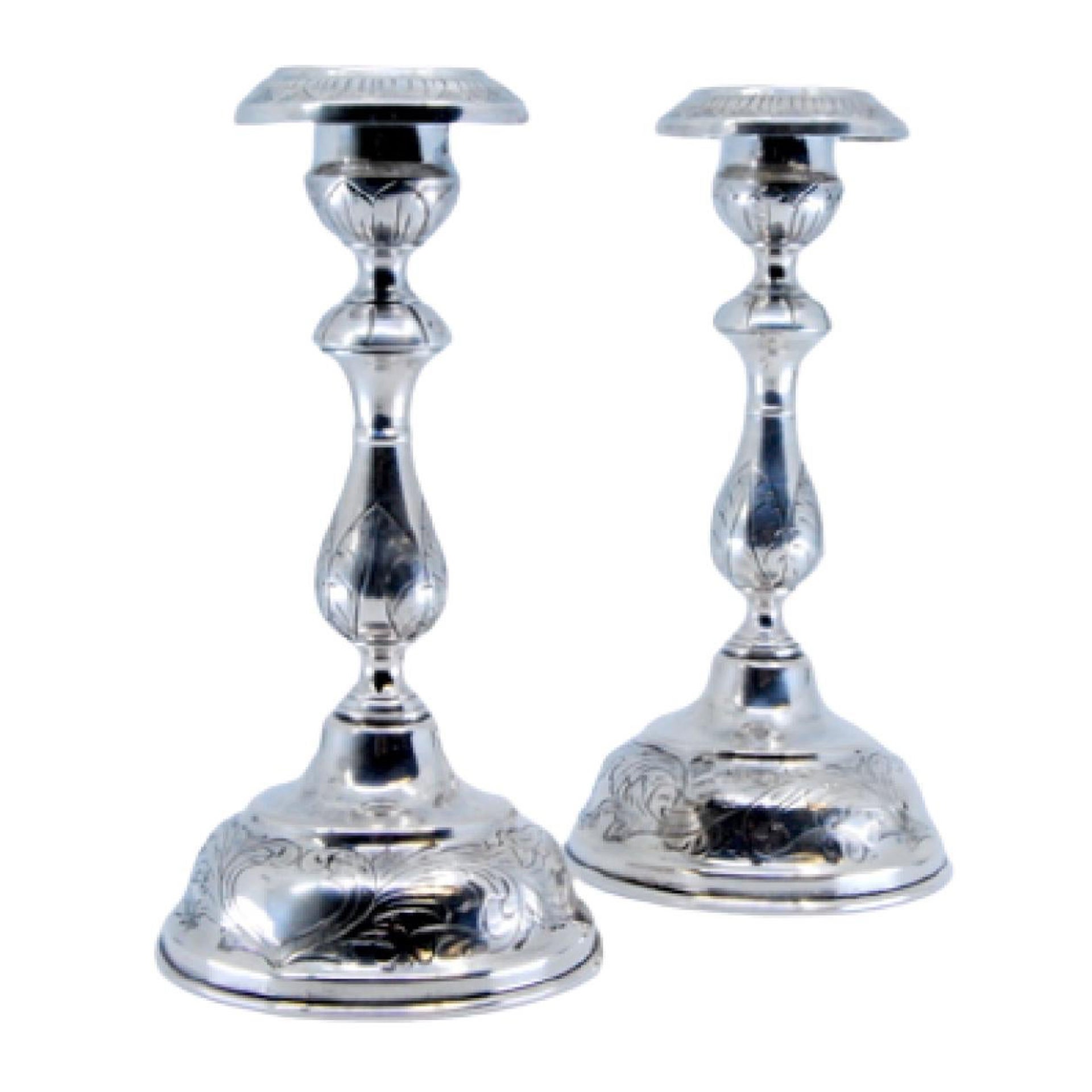 Silver candlesticks with floral engravings on sconces, shafts and circular bases
