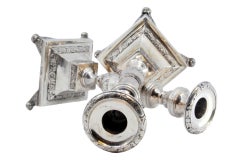 Silver candlesticks with floral engravings on square bases with round feet