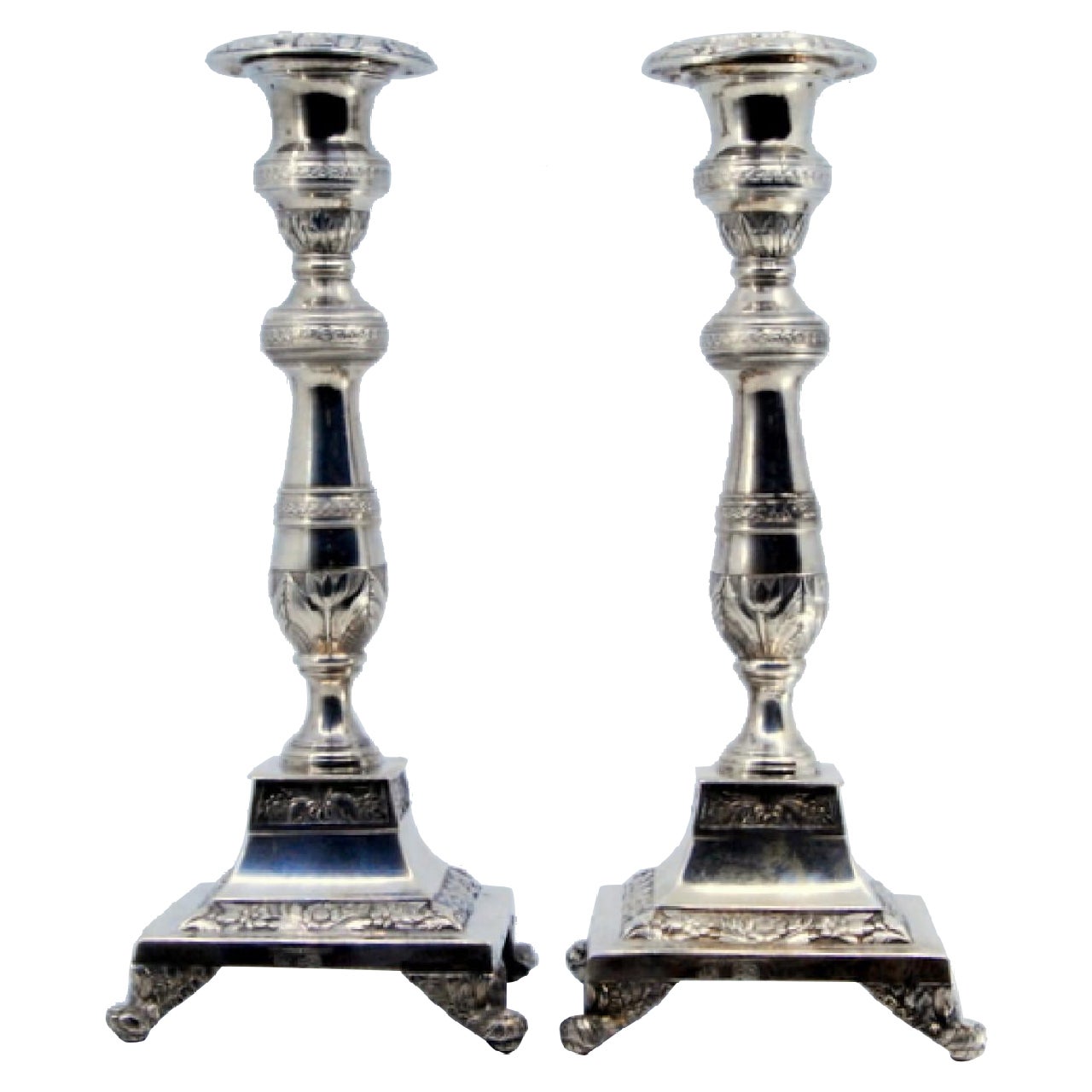 Silver candlesticks with floral engravings on square bases with round feet