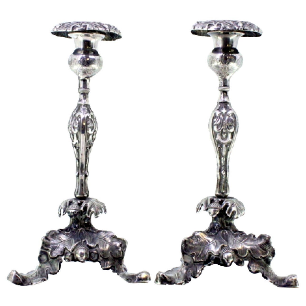 Silver candlesticks with floral reliefs and acanthus-shaped tripod bases