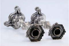 Silver candlesticks with grated stems on hexagonal bases over swans