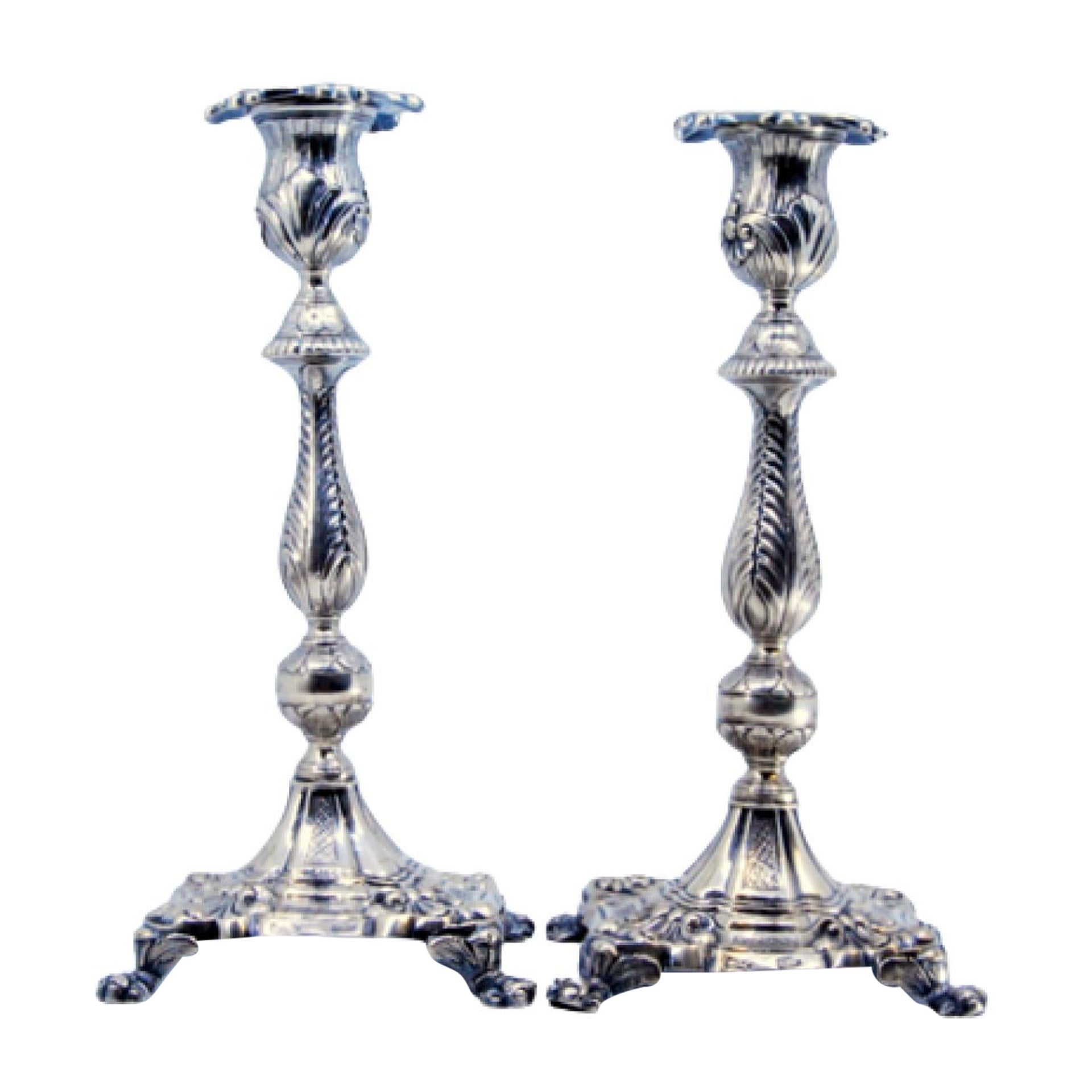 Silver candlesticks with palm-embossed stems on shell bases with claw feet