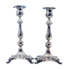 Silver candlesticks with palm-embossed stems on shell bases with claw feet