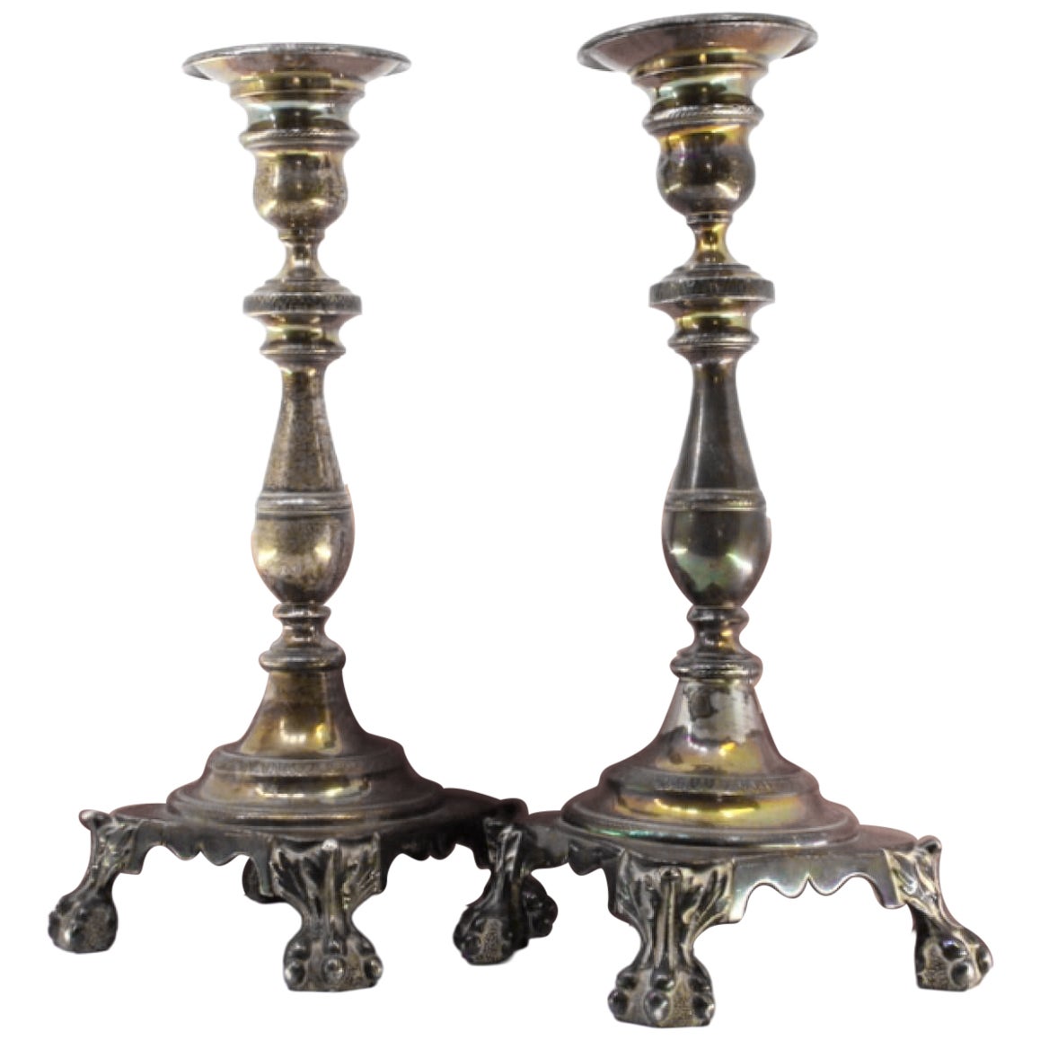 Silver candlesticks with relief stems and four claw feet on square bases