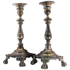 Silver candlesticks with relief stems and four claw feet on square bases