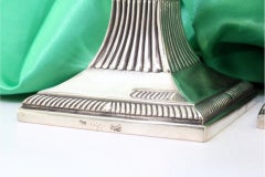 Silberne Kerzenhalter mit Reliefs und Kanneluren auf quadratischen Sockeln im D. A. Style