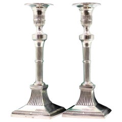 Candelieri in argento con rilievi e scanalature su basi quadrate in stile D. A. Style