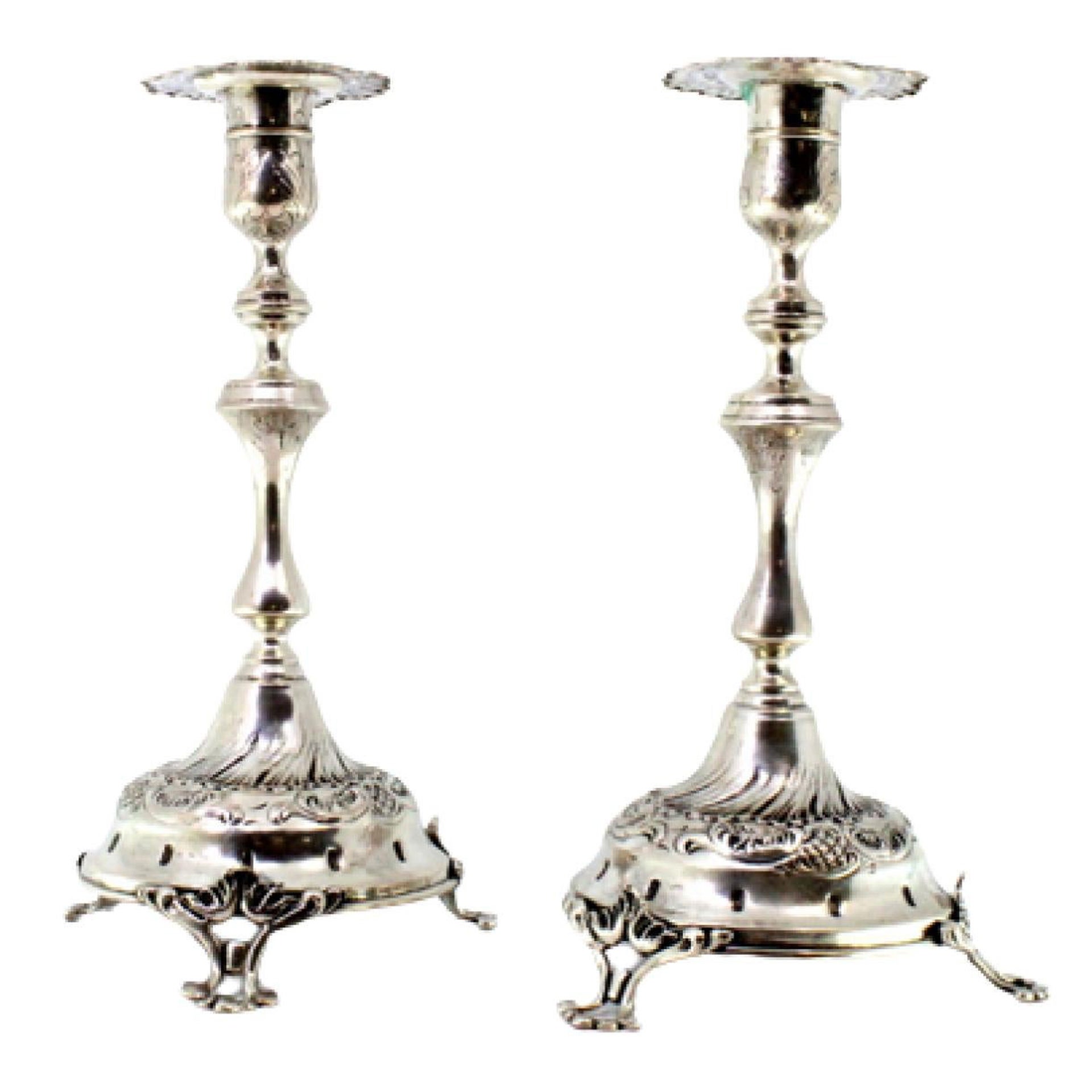 Silver candlesticks with reliefs, turned shafts and three cut-out feet