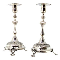 Silver candlesticks with reliefs, turned shafts and three cut-out feet