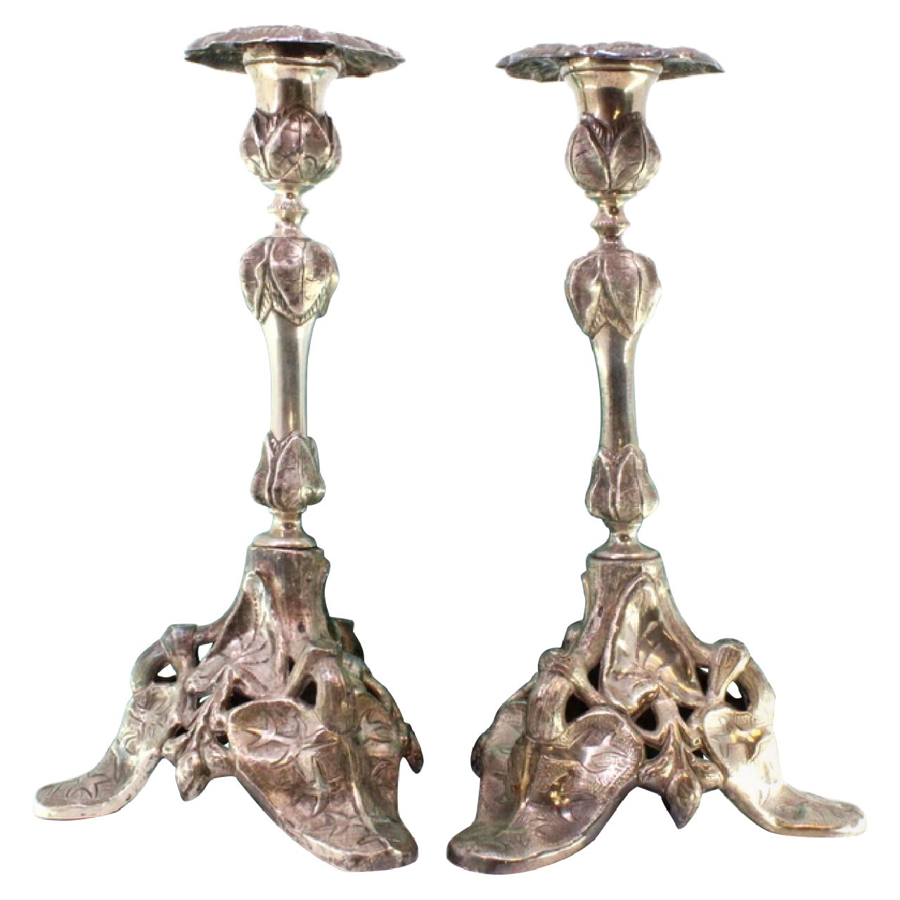Silver candlesticks with stems and tripod bases cut with reliefs