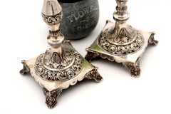 Silver candlesticks with turned and engraved shafts, resting on square bases