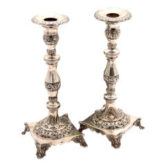 Silver candlesticks with turned and engraved shafts, resting on square bases