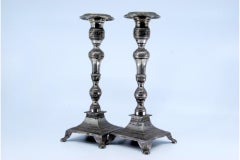 Silver candlesticks with turned embossed shafts on square bases with four legs