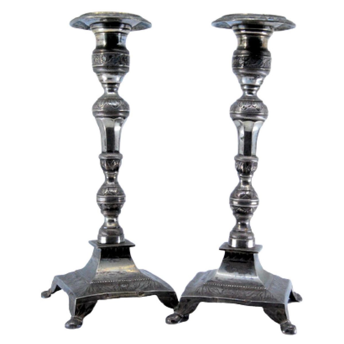 Silver candlesticks with turned embossed shafts on square bases with four legs
