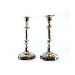 Silver candlesticks with turned shafts and hexagonal bases with friezes