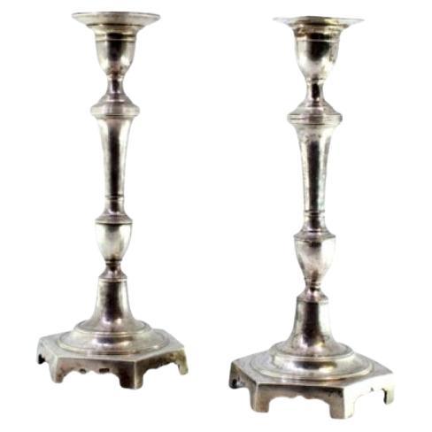 Silver candlesticks with turned shafts and hexagonal bases with friezes