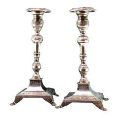 Silver candlesticks with turned shafts on square bases with claw feet