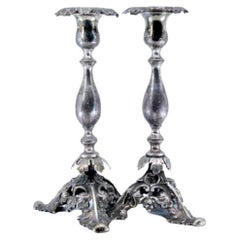 Silver candlesticks with turned stems 
acanthus-cut bases