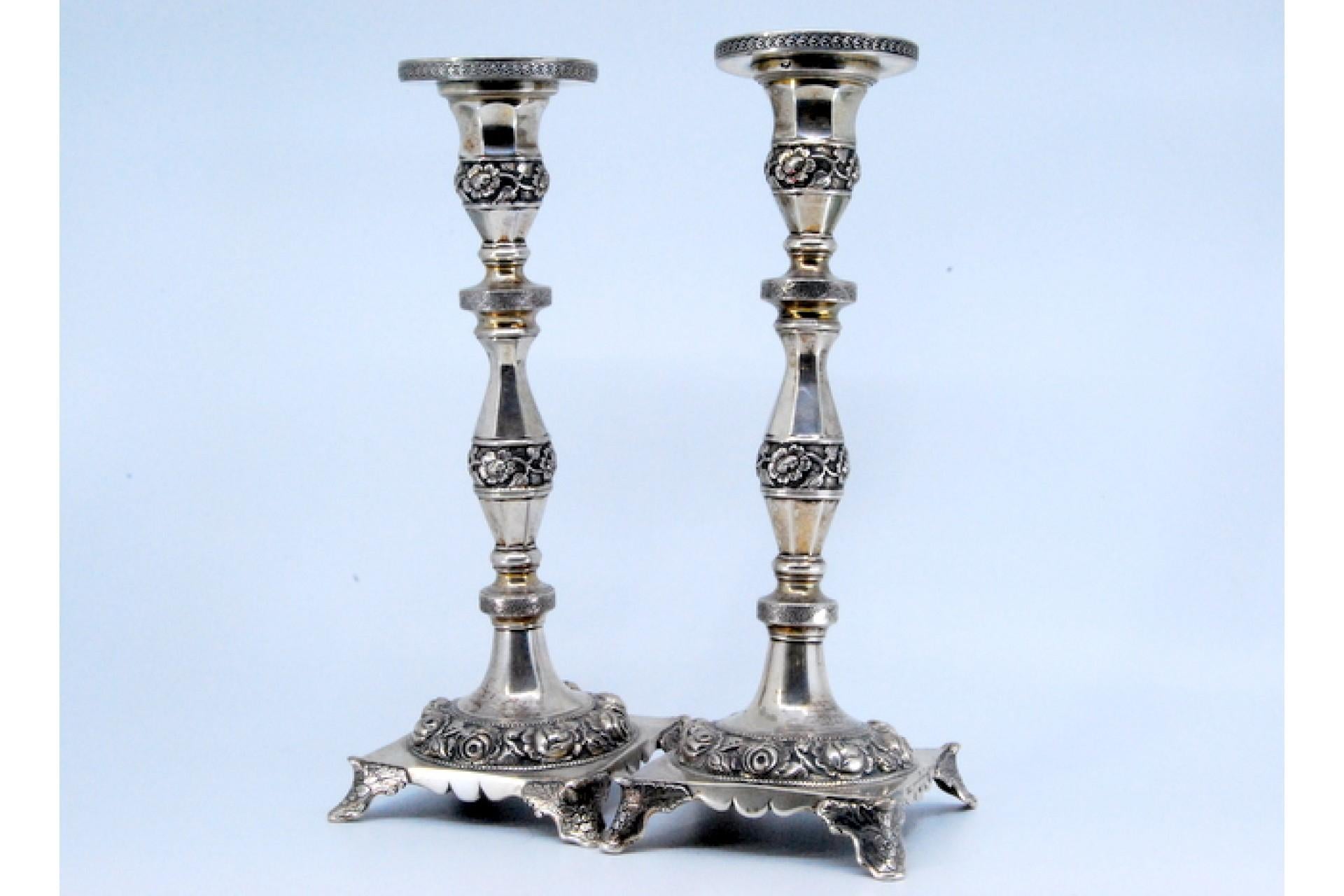 Description: Silver candlesticks with turned shafts and relief floral motifs, base resting on four feet. Metal: Silver. Origin: Portuguese. Brand: Porto Coroa. Weight: 796.43 grams. Dimensions: 22.5x8cm. Content: 833/1000. Assay Mark: Yes, from the