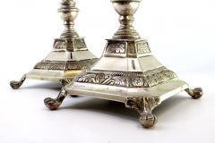 Silver candlesticks with turned stems on square bases with claw feet