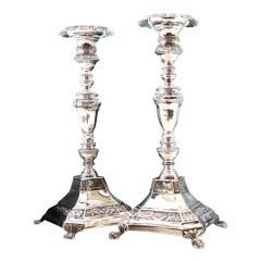 Silver candlesticks with turned stems on square bases with claw feet