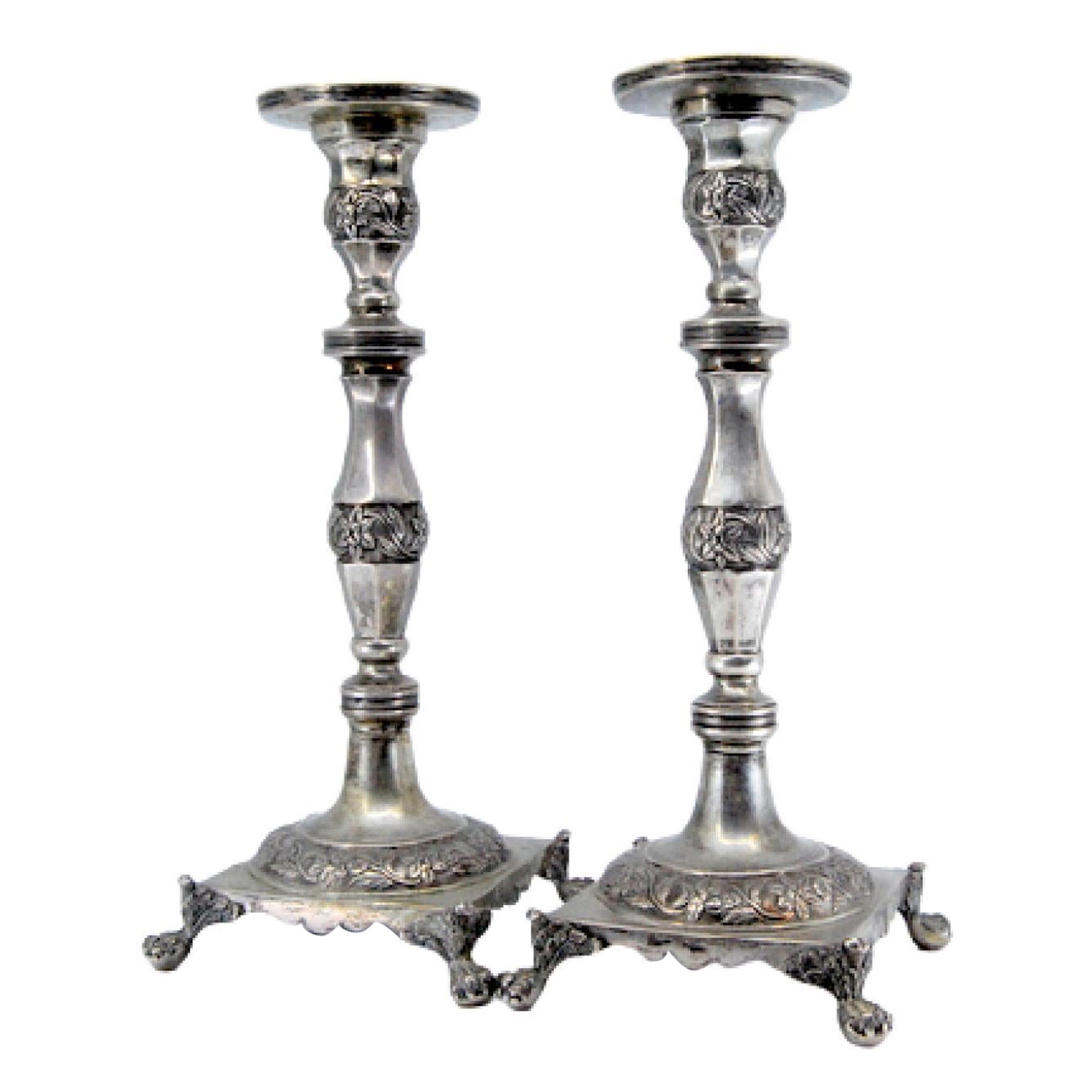 Silver candlesticks with turned stems on square bases with claw feet