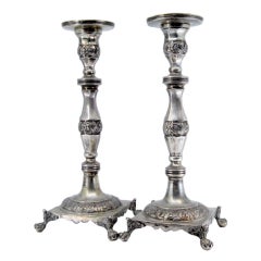 Silver candlesticks with turned stems on square bases with claw feet