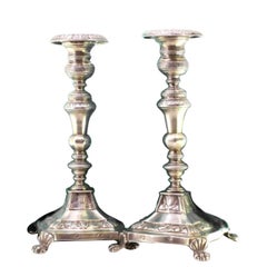 Silver candlesticks with turned stems on square bases with claw feet
