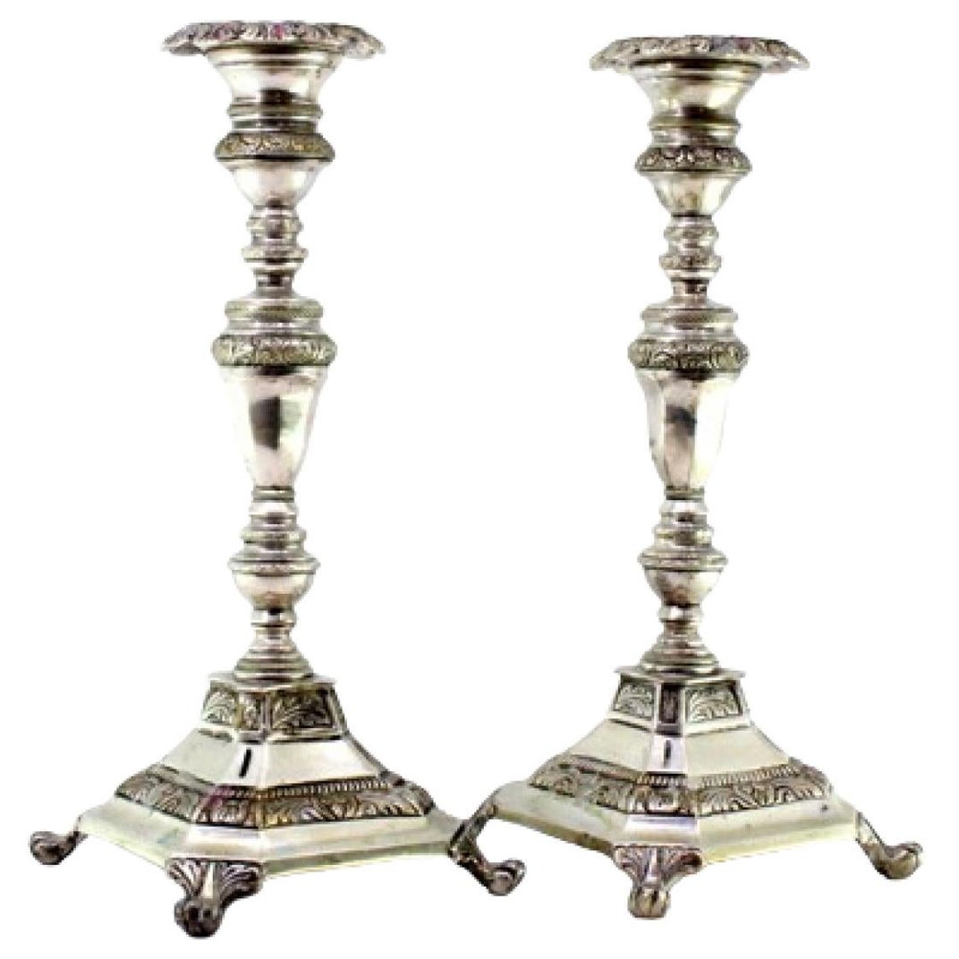 Silver candlesticks with turned stems on square bases with claw feet