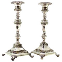 Silver candlesticks with turned stems on square bases with claw feet