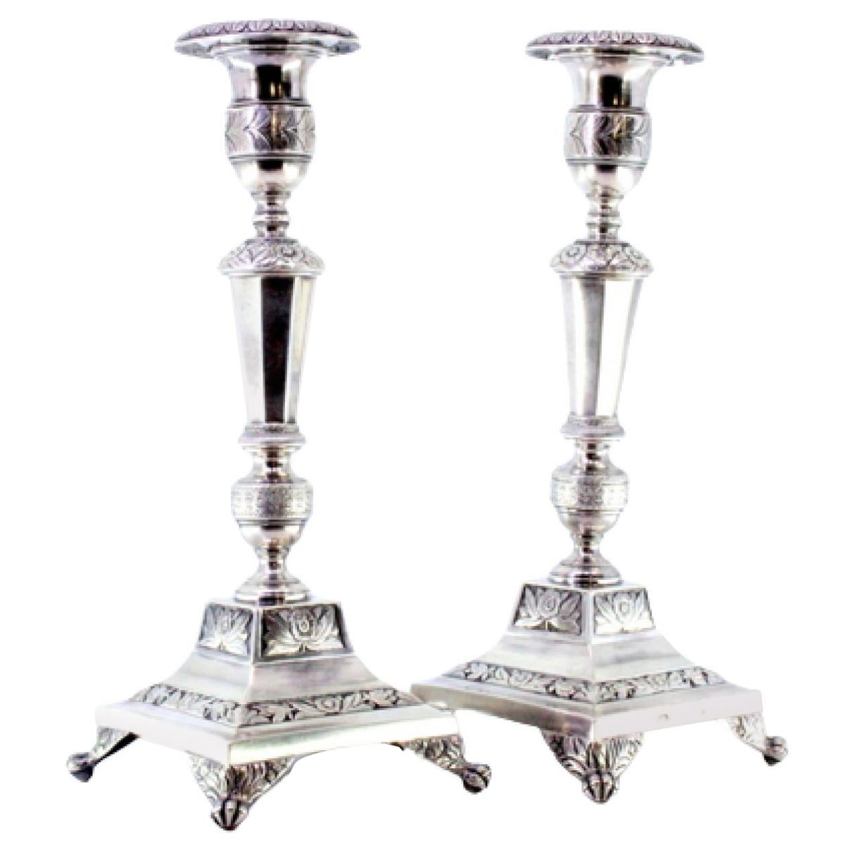 Silver candlesticks with turned stems, sconces and chiseled bases with claw feet