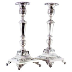 Silver candlesticks with turned stems, sconces and chiseled bases with claw feet
