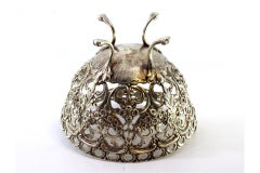 Silver candy box w/ cutouts & reliefs, resting on four raised claw-shaped feet