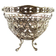 Silver candy box w/ cutouts 
reliefs, resting on four raised claw-shaped feet