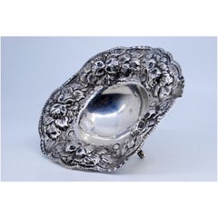 Silver candy box with reliefs and floral motifs and three support feet